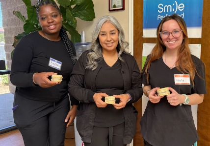 Tucson DAS students smiling while proudly holding whitening trays they made during lab training